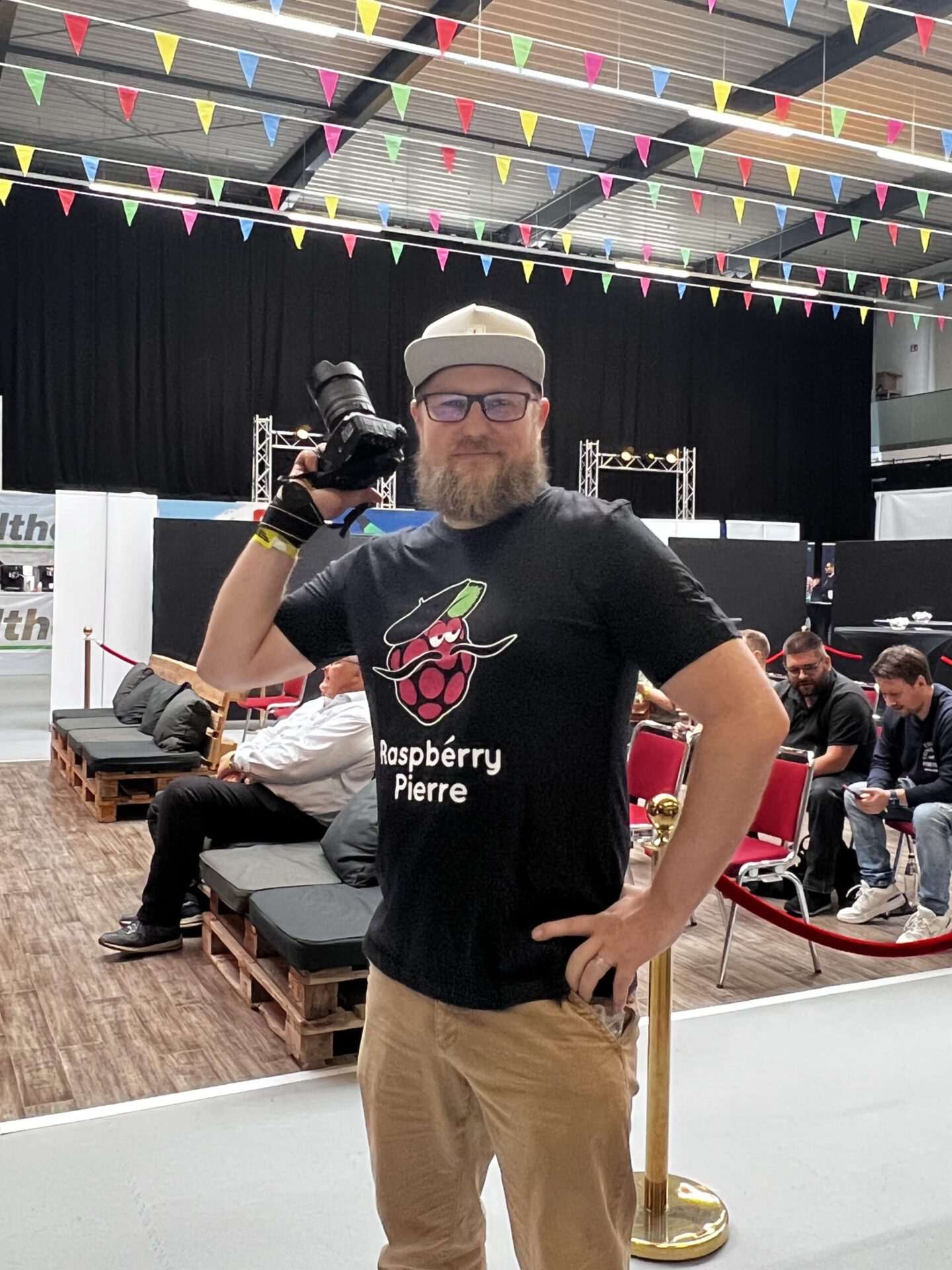 Raspberry Pierre Fan trägt T-Shirt während er auf einer Messe Fotos macht